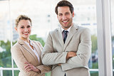 Business people posing with arms crossed smiling at camera