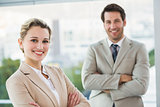 Business people posing with arms crossed smiling at camera
