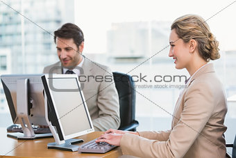 Smiling business people using computer