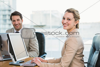 Two young business people using computer