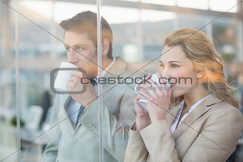 Business people drinking cup of coffee through the window