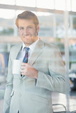 Businessman holding cup of coffee through the window