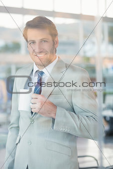 Businessman holding cup of coffee through the window