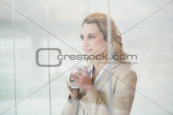 Pretty blonde holding cup of coffee through the window