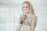 Businesswoman holding cup of coffee through the window