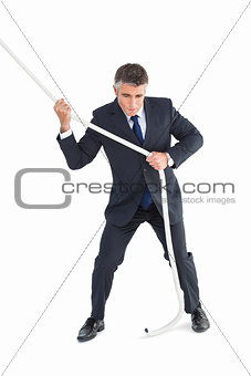 Businessman in suit pulling a rope