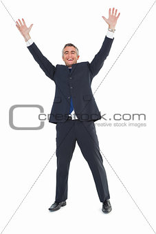Happy businessman in suit with arms up