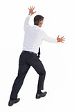 Businessman standing and pushing a wall
