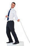Smiling businessman standing on a cube and pulling rope