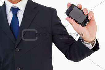 Mid section of a businessman holding smartphone