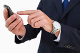 Mid section of a businessman typing on his phone