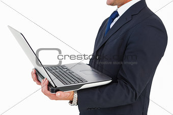 Mid section of a businessman holding laptop