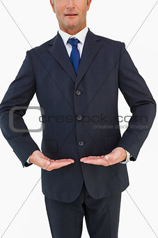 Mid section of a businessman in suit with hands out