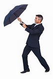 Businessman pushing the wind with umbrella