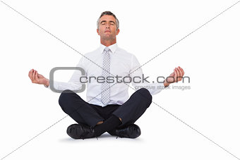 Peaceful businessman sitting in lotus pose