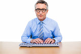 Focused businessman with glasses typing on keyboard