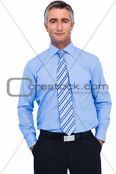 Cheerful businessman with hands in pocket posing