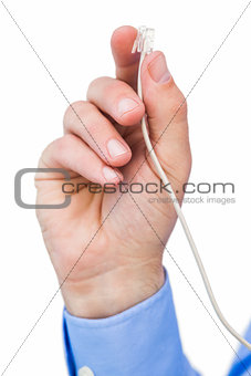 Hand of a businessman holding a white cable