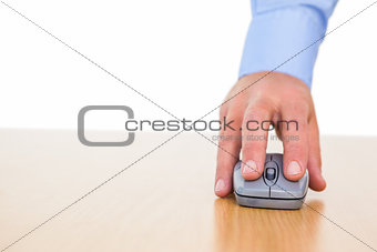 Hand of a businessman using mouse at desk
