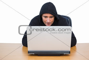 Burglar in hood jacket using laptop