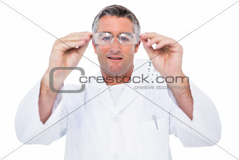 Optician in coat holding glasses