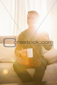 Smiling man on the phone and holding mug