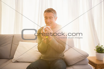 Smiling man enjoying hot drink
