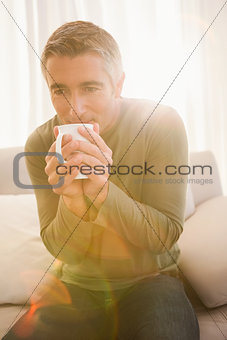 Smiling man drinking hot beverage