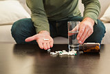 Casual man showing pills on open hand