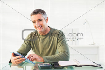 Smiling casual man using tablet pc