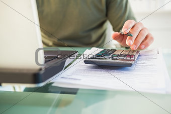 Man using laptop and calculator