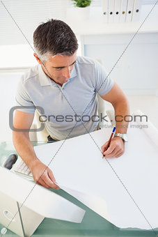 Man with grey hair drawing on paper