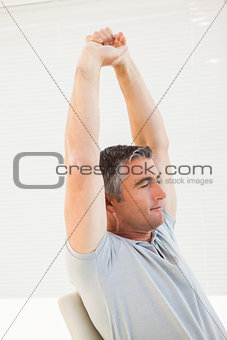 Peaceful man with eyes closed stretching