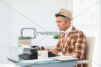 Retro man in straw hat typing on typewriter