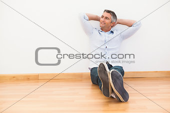 Smiling man sitting on the parquet relaxing