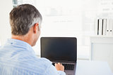 Man with grey hair using his laptop