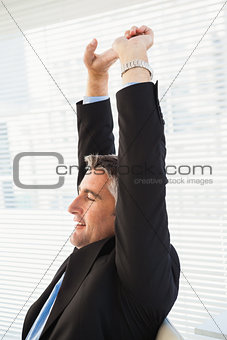 Peaceful businessman stretching his arms