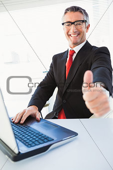 Positive businessman in suit with thumbs up