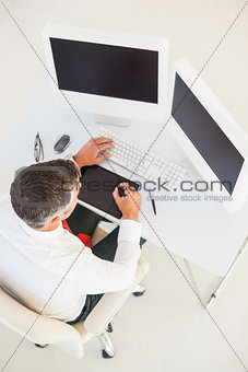 Businessman using computer and tablet