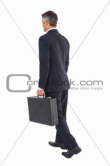 Businessman walking and holding briefcase