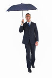 Happy businessman sheltering with umbrella