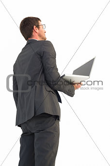 Businessman looking up holding laptop