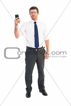 Serious businessman holding his phone