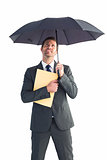 Businessman sheltering under umbrella holding file