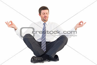 Businessman meditating in lotus pose