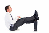 Businessman with feet up on briefcase