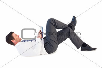 Businessman lying and using tablet