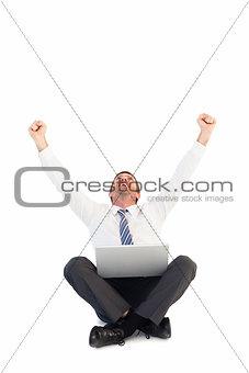 Businessman using laptop and cheering