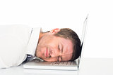 Tired businessman resting on laptop
