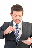 Businessman looking at tablet with magnifying glass